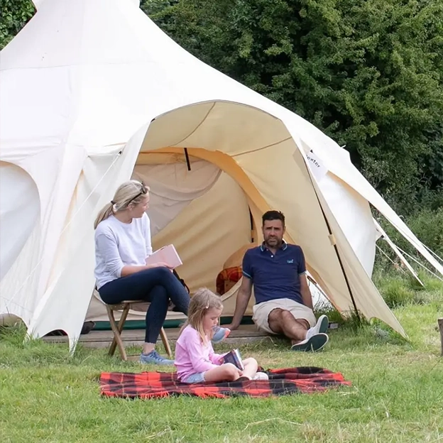 Family sitting outside tent