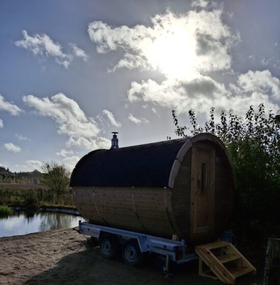 Wood-fired outdoor sauna by natural swimming pool